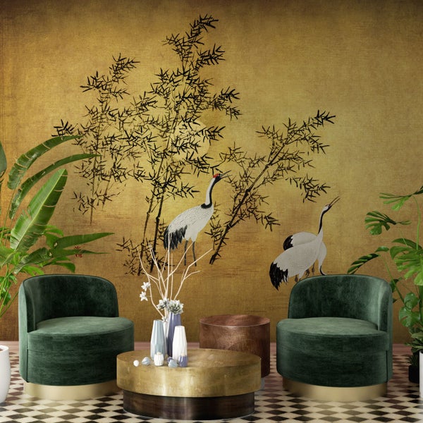 Wohnzimmer mit Tapete mit Kranichmotiv, zwei grünen Sesseln und Couchtischen