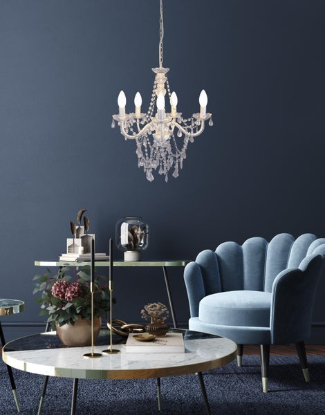 Elegantes Wohnzimmer mit Kristalllüster, Sessel und Beistelltischen.