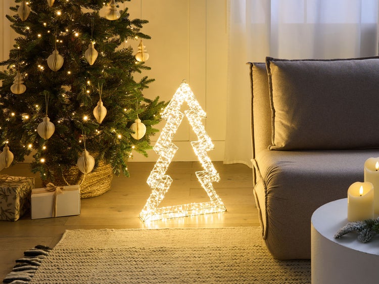 Festliche Szene mit Weihnachtsbaum, beleuchteter Weihnachtsbaumfigur, Geschenken, Sofa und Kerzen