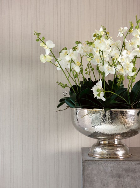 Dekorative Orchideen in einer silberfarbenen Vase