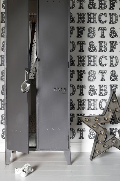 Grauer Metallschrank mit teilweise geöffneter Tür in einem Raum mit Buchstaben-Tapete und Sternenleuchte