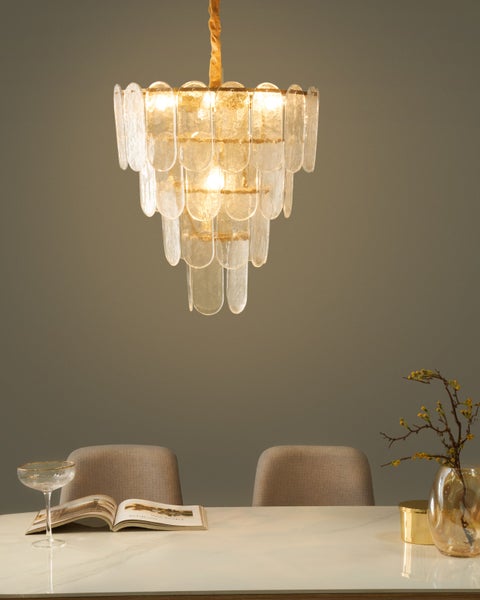 Glas-Hängeleuchte über einem Esstisch mit Dekoration