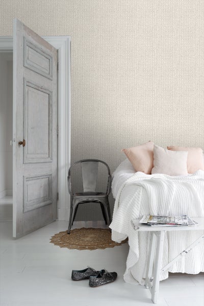 Helles Schlafzimmer mit Stricktapete, Bett, Stuhl und Dekoration