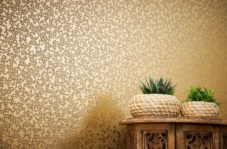 Dekorative gemusterte Tapete im Interieur mit Pflanzen auf einem Holztisch.