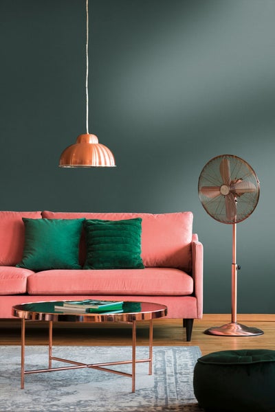 Wohnzimmer mit grauer Marmortapete, Ecksofa, Sessel und dekorativem Teppich