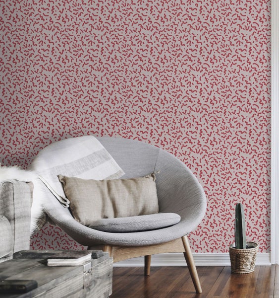 Wohnzimmer mit gemusterter Tapete, Sessel und Holzboden für eine gemütliche Atmosphäre.