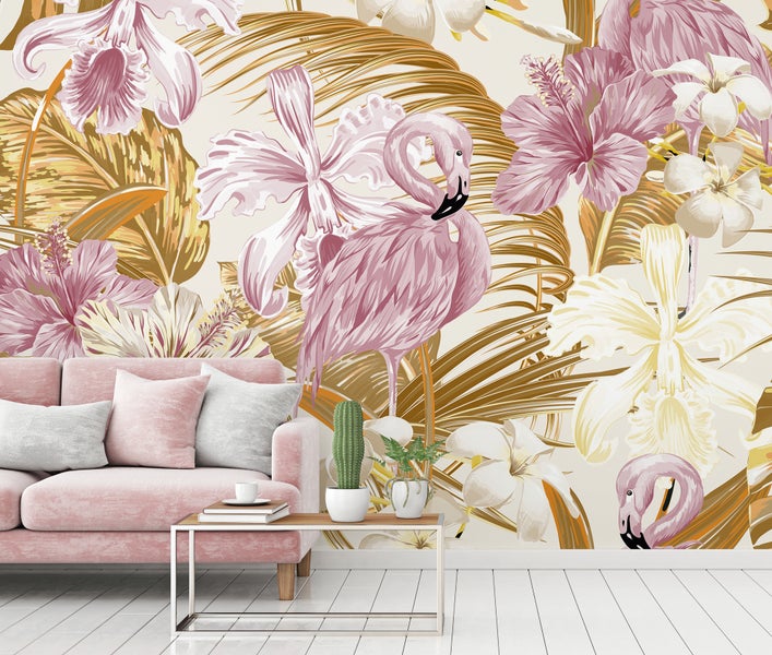 Fototapete mit Flamingos, Hibiskusblüten und goldenen Palmenblättern in einem modern eingerichteten Wohnzimmer hinter einem rosa Sofa.