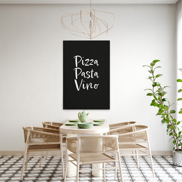Dekoratives Wandbild mit dem Text Pizza Pasta Vino über einem Esstisch.