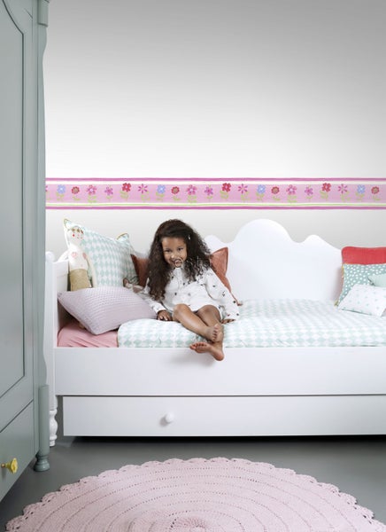 Kinderzimmer mit weißem Bett, Mädchen und Blumengirlande als Wandbordüre