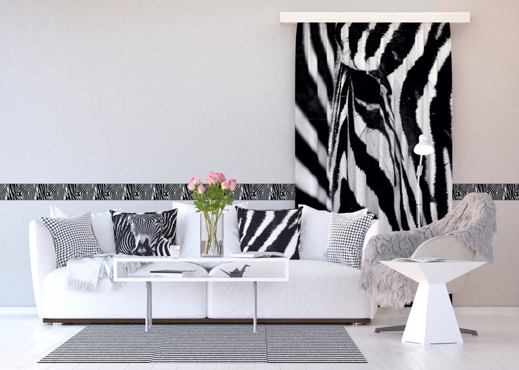 Wohnzimmer mit Sofa, Couchtisch, Stuhl, Lampe, Bordüre, Gardine und Teppich im Zebra Design