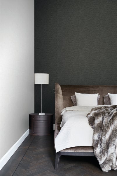 Schlafzimmer mit gemusterter Tapete, Bett, Nachttisch und Stehlampe