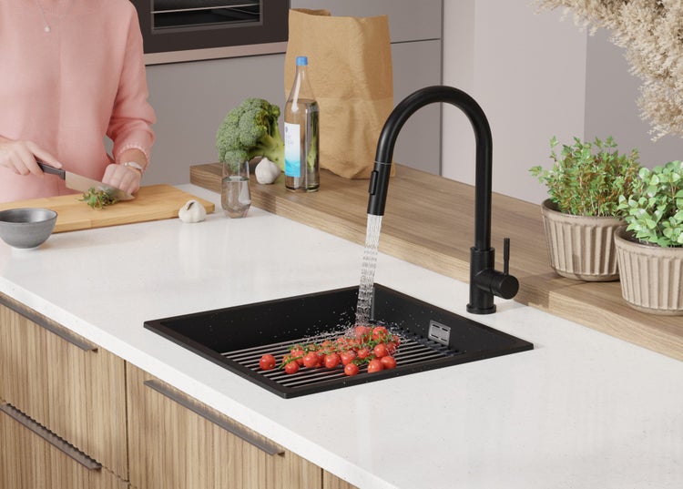 Moderne Küche mit schwarzem Spülbecken, Armatur und gewaschenen Tomaten