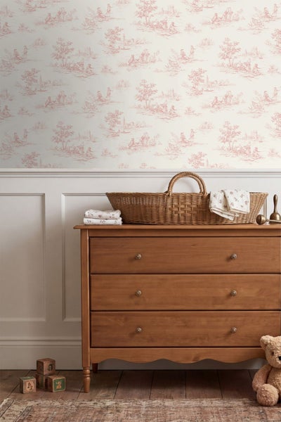 Tapete mit Toile-de-Jouy-Muster in einem Kinderzimmer über einer Wandvertäfelung und einer Holzkommode mit Weidenkorb.