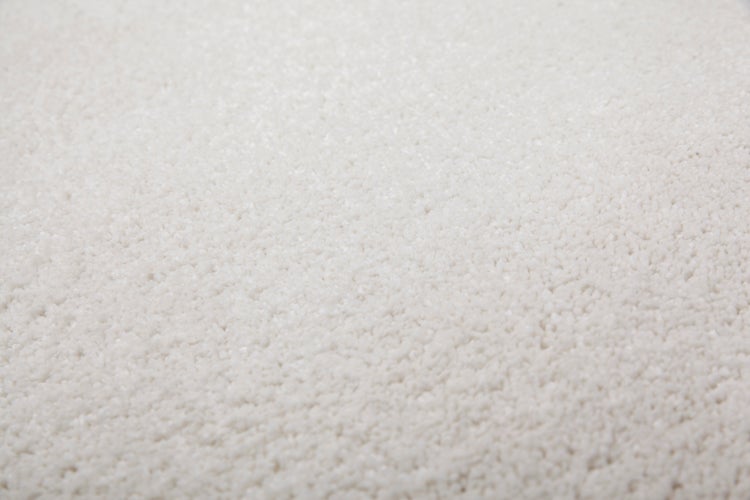 Nahaufnahme eines hochflorigen Teppichs mit weicher, zotteliger Textur.