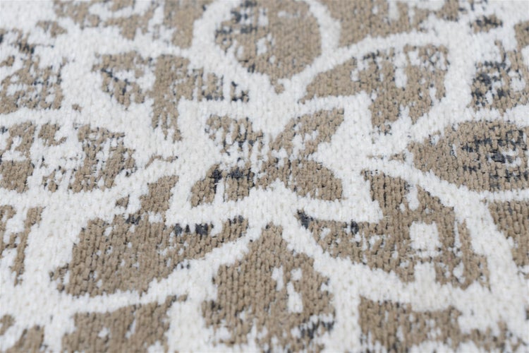 Nahaufnahme eines gewebten Teppichs in Beige und Weiß mit floralem Muster und strukturierter Oberfläche.