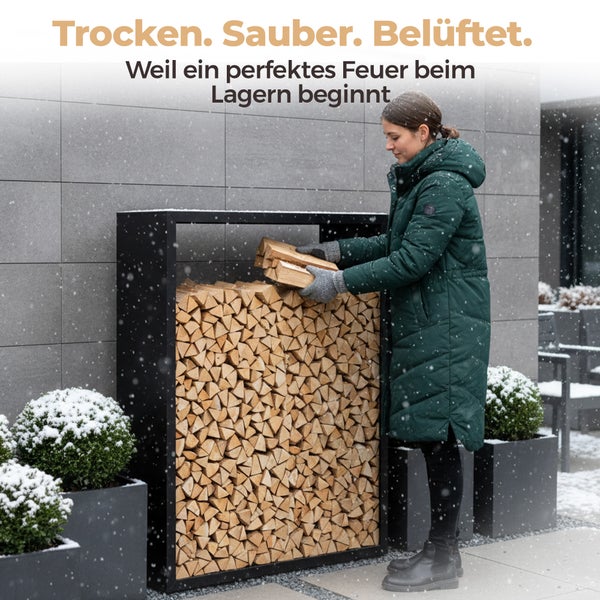 Frau befüllt Brennholzregal mit Holzscheiten im Garten