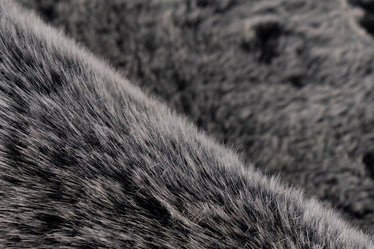 Detailaufnahme eines flauschigen grauen Kunstfellteppichs mit langem Flor.