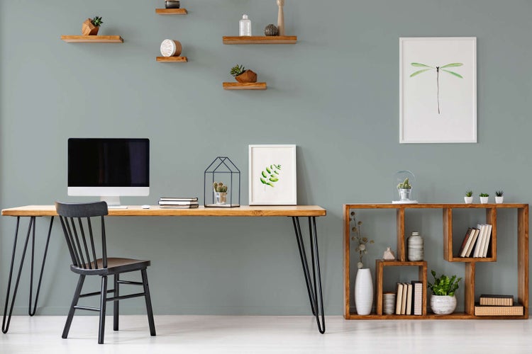 Moderner Arbeitsplatz mit Schreibtisch aus Holz, schwarzem Stuhl und asymmetrischem Standregal sowie schwebenden Wandregalen.