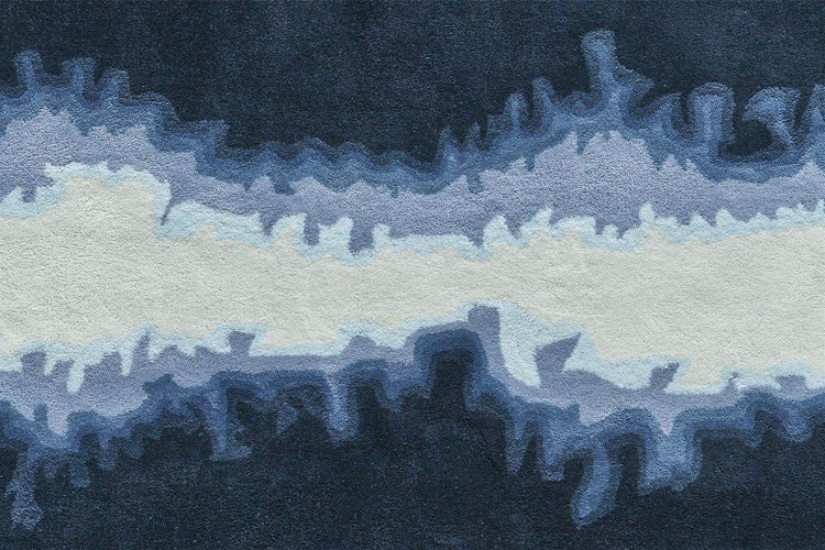 Teppich mit abstraktem Wellenmuster in Blau- und Weißtönen, weiche Oberfläche.