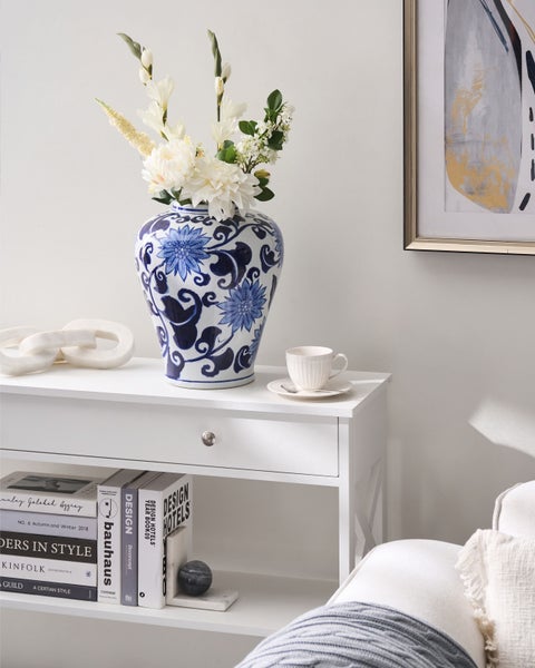 Dekorative Szene mit Tisch, Blumenvase und Kunstwerk für ein stilvolles Wohnambiente