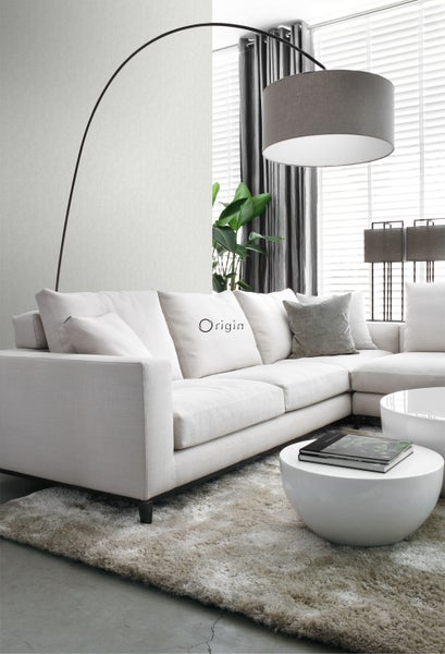 Wohnzimmer mit Ecksofa, Bogenlampe und Couchtischen