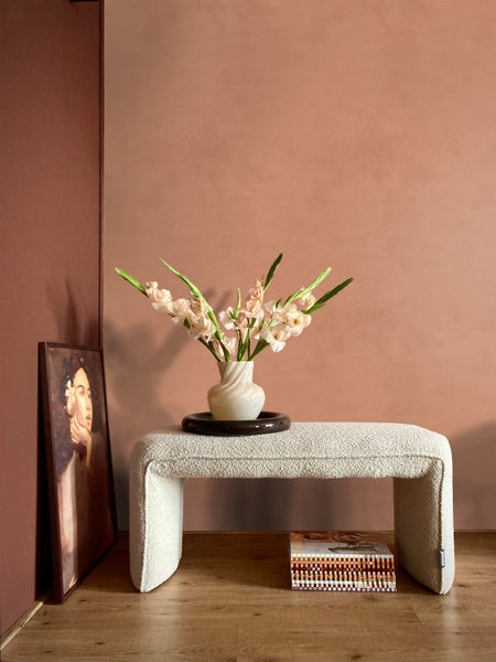 Dekoratives Wohnambiente mit Sitzbank, Blumenvase und Gemälde