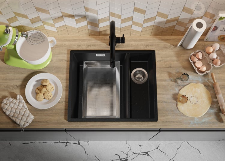 Küchenszene mit Spüle, Armatur, Küchenmaschine, Gebäck und Backzutaten auf einer Arbeitsplatte.