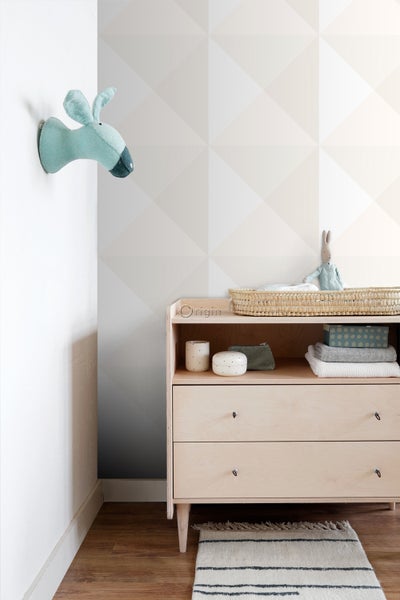 Helles, freundliches Kinderzimmer mit Wickelkommode, Wanddekoration und Teppich