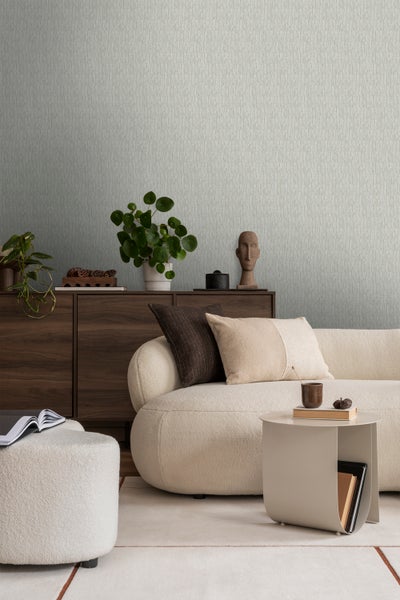 Wohnzimmer mit gemusterter Tapete, Sofa und Holzkommode