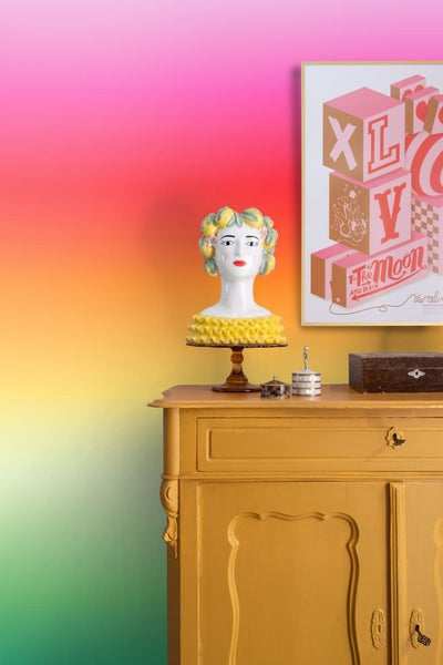 Kommode mit dekorativer Keramikbüste und einem gerahmten Poster