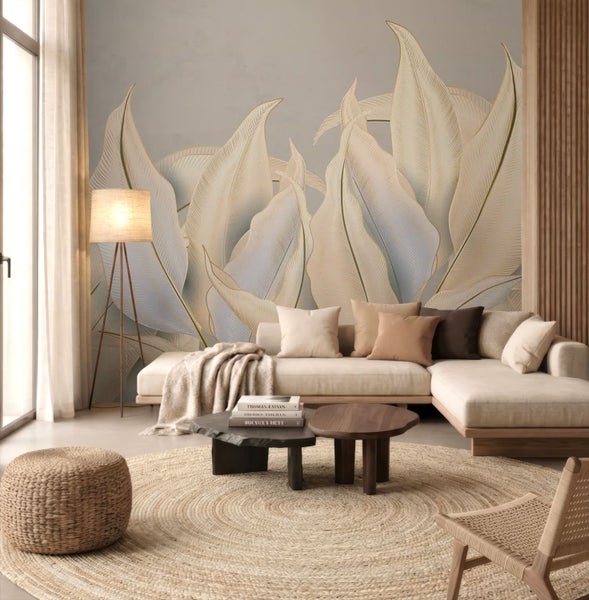 Modernes Wohnzimmer mit großer Fototapete mit Blattmotiven, hellem Ecksofa, rundem Juteteppich und Beistelltischen aus Holz.