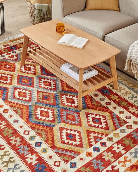 Beispielszene mit einem Teppich mit geometrischem Muster, einem Holztisch und einem Sofa.