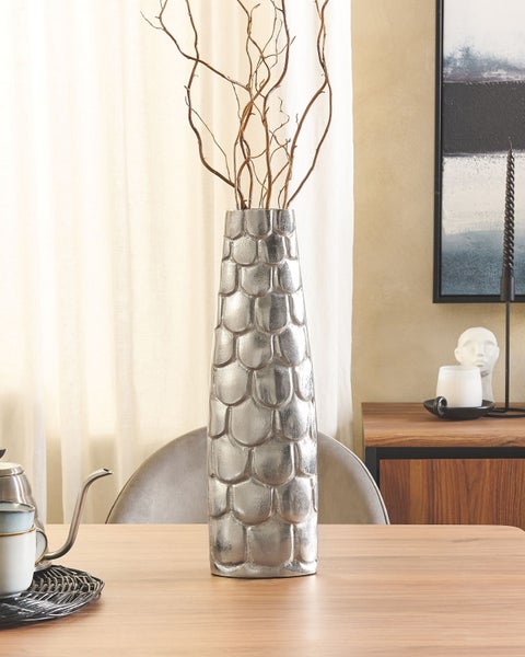 Dekorative silberfarbene Vase mit Ästen auf einem Holztisch