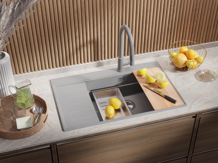 Küchenspüle mit Armatur, Schneidebrett und Zubehör auf einer Küchentheke