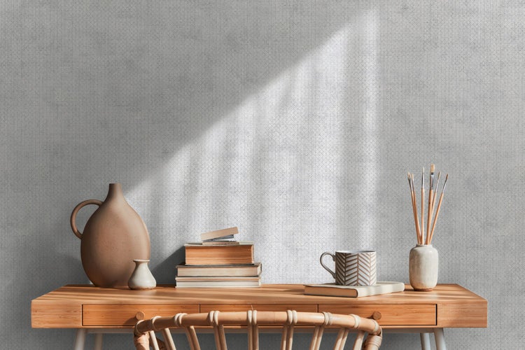 Schreibtisch mit Dekoration und gemusterter Tapete im Hintergrund für ein helles Raumgefühl.
