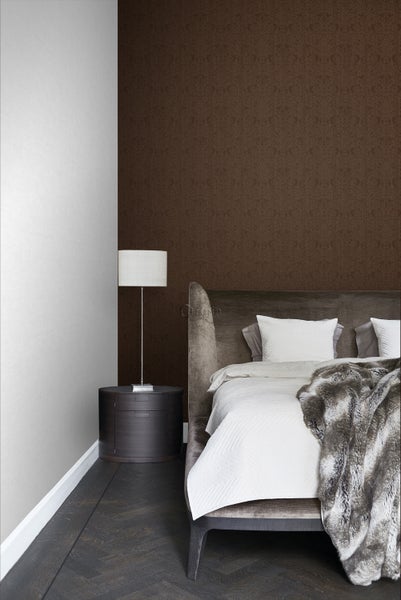 Schlafzimmer mit Bett, Nachttischlampe und gemusterter Tapete für eine gemütliche Atmosphäre.