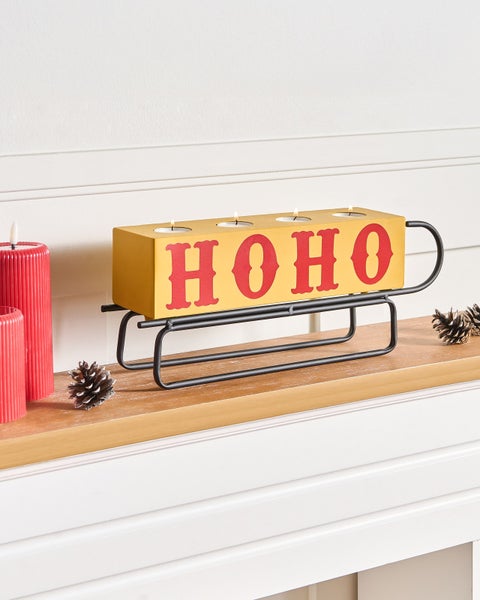 Kerzenhalter mit Aufschrift Ho Ho Ho auf einem schwarzen Metallschlitten mit Teelichtern