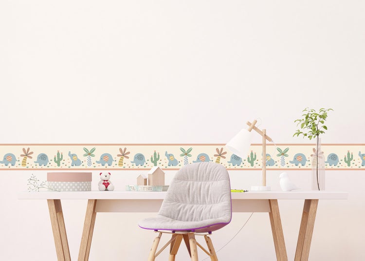 Tapetenbordüre für das Kinderzimmer mit Motiven von Elefanten, Palmen und Kakteen über einem Schreibtisch in einem hellen Zimmer.