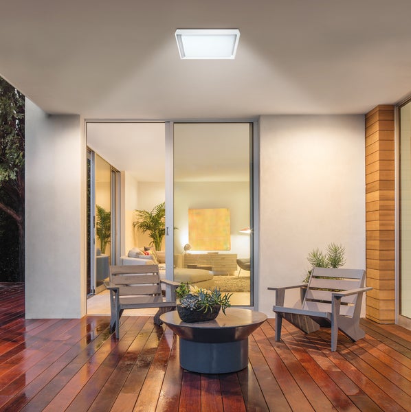 Terrasse mit Holzdeck, Gartenmöbeln und quadratischer Deckenleuchte.