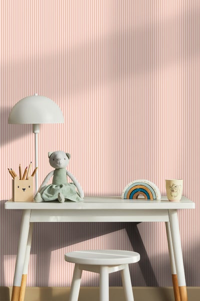 Kinderzimmer mit Schreibtisch, Stuhl, Lampe und Spielzeug vor einer Tapete mit Streifenmuster