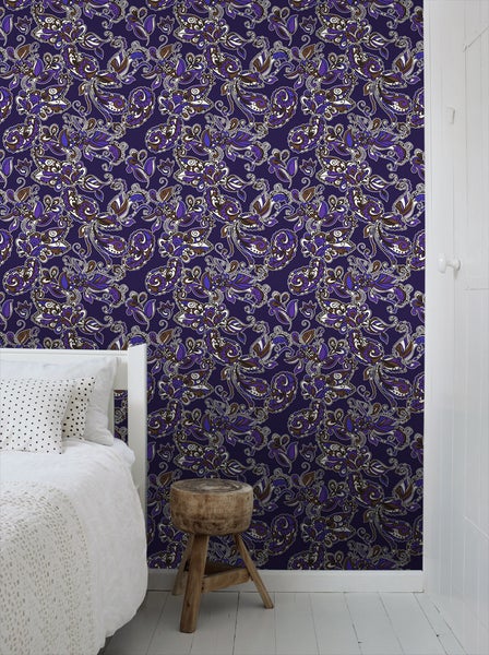 Raum mit Tapete mit Paisleymuster, Bett, Holzhocker und Tür