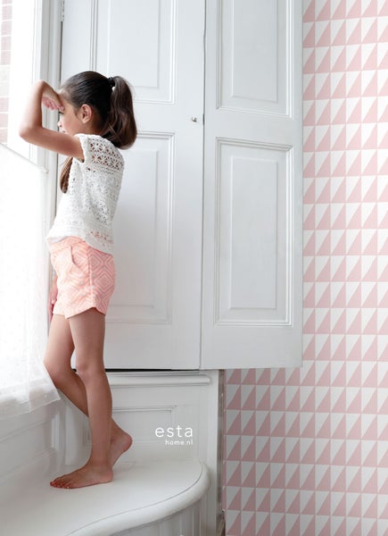 Mädchen steht vor weißer Fenstertür, Wand mit dreieckigem Tapetenmuster