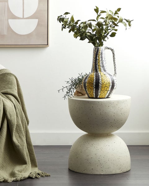 Dekoratives Arrangement mit einer Vase auf einem Beistelltisch