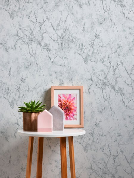 Dekoratives Stillleben mit Marmortapete, Tisch, Pflanze und Bild