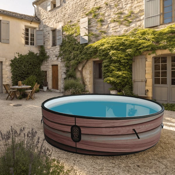 Aufblasbarer Whirlpool in runder Form mit Holzoptik-Verkleidung in einem hellen, rustikalen Innenhof mit Steinwänden.