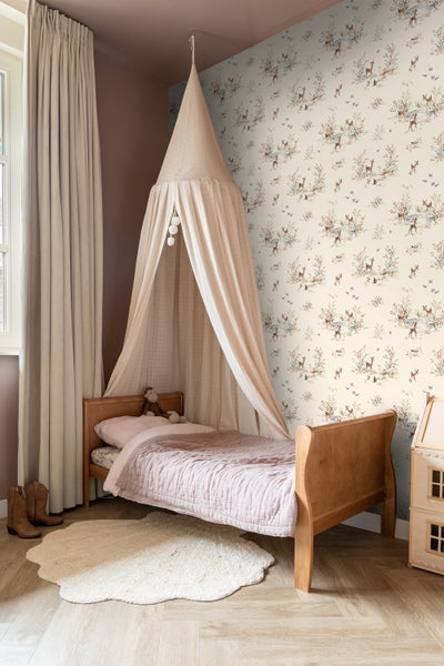Zimmeransicht mit Tapete mit Hirschmotiv, Holzhakenleiste, Kinderkleidung und Weidenkorb