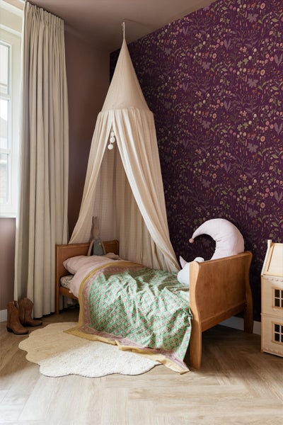 Kinderzimmer mit Himmelbett, floraler Tapete und Holzfußboden