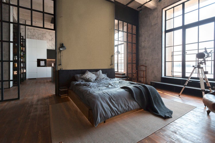 Schlafzimmer im Loft-Stil mit Bett, Teppich und Industrie-Designelementen