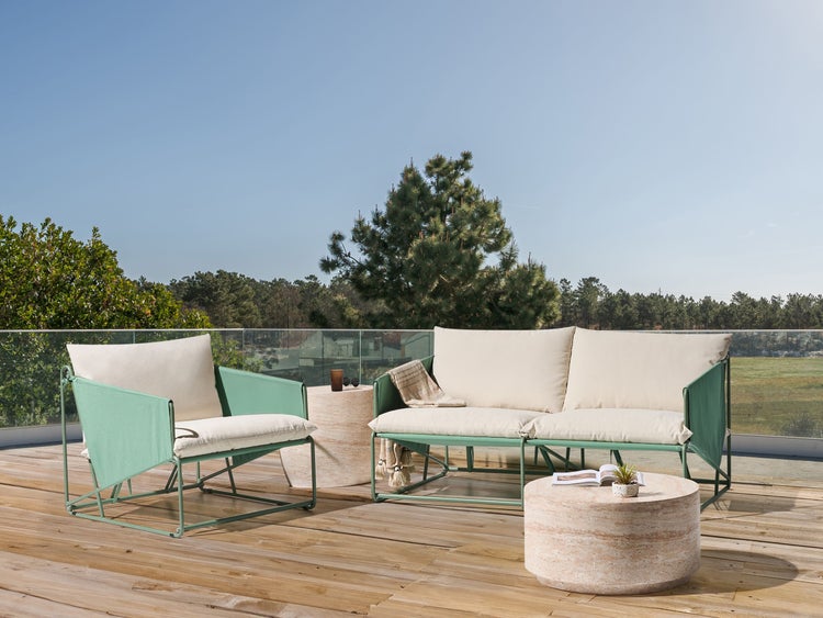 Gartensitzgruppe mit Sessel, Sofa und Beistelltischen auf einer Holzterrasse