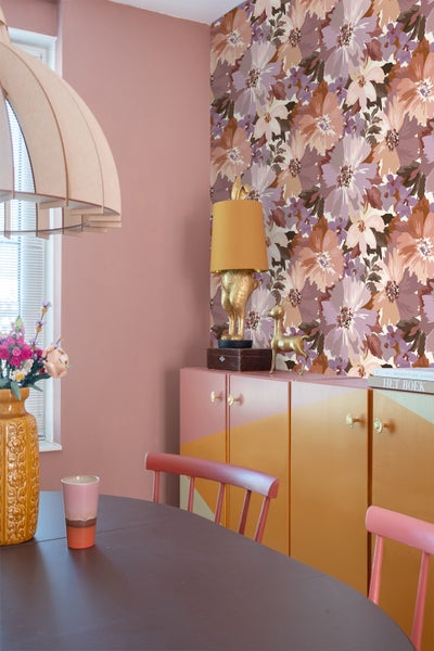 Esszimmer mit Esstisch, Stühlen, Kommode und geblümter Tapete
